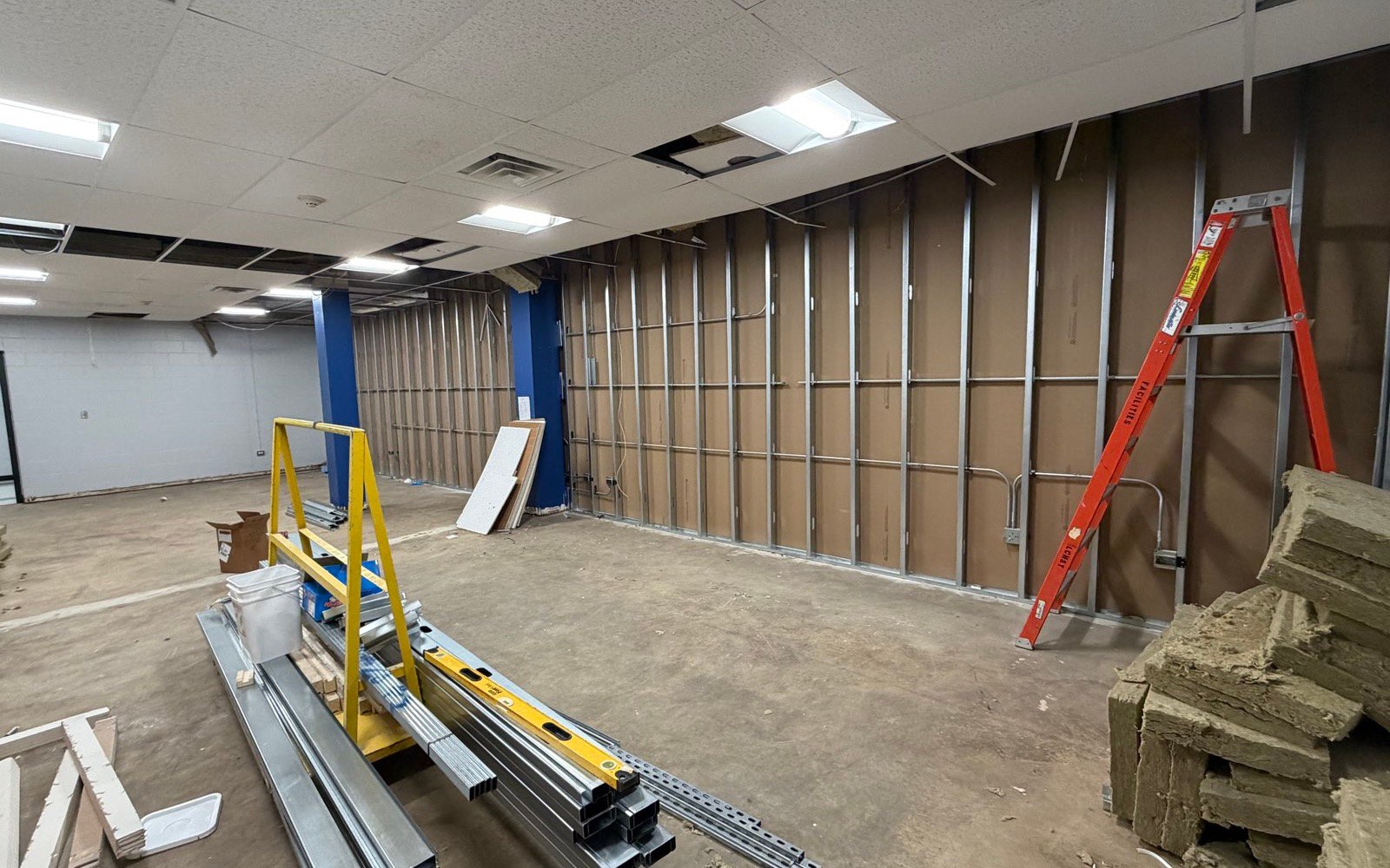 Commercial room at rough-in, metal stud framing open and electrical exposed