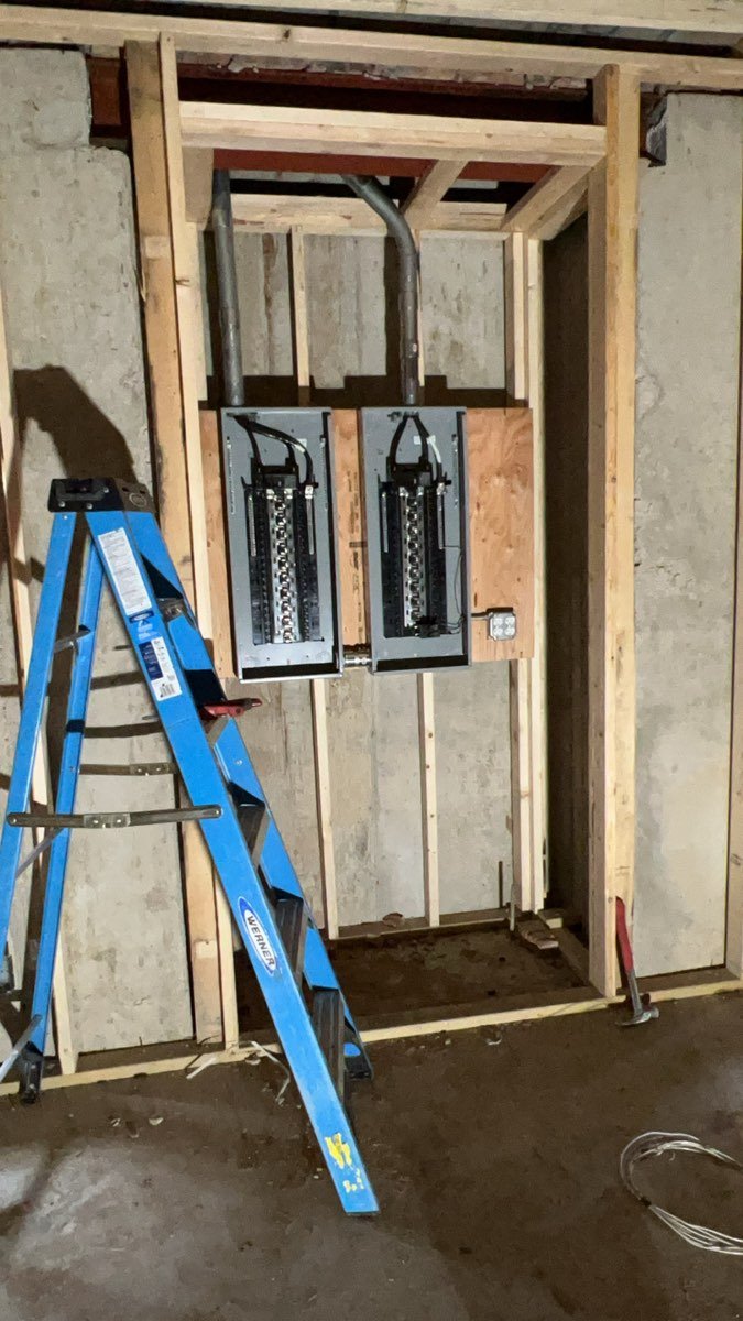Electrical panels roughed in on a framed wall before drywall