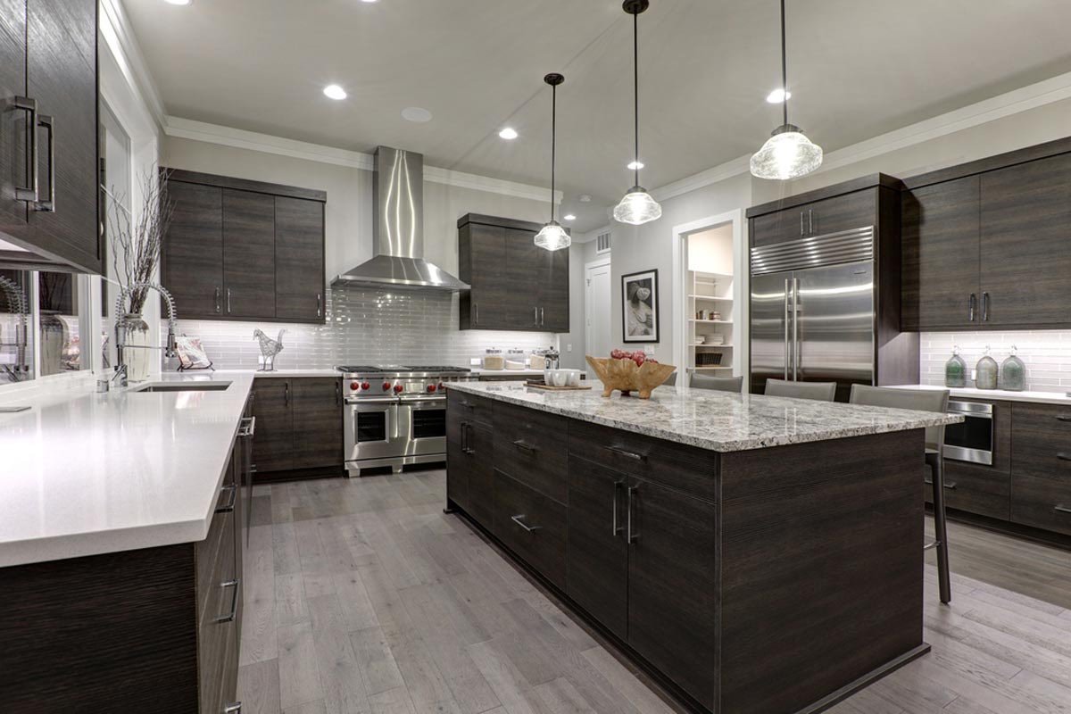 Finished kitchen remodel with dark cabinets, quartz counters and pendant lighting